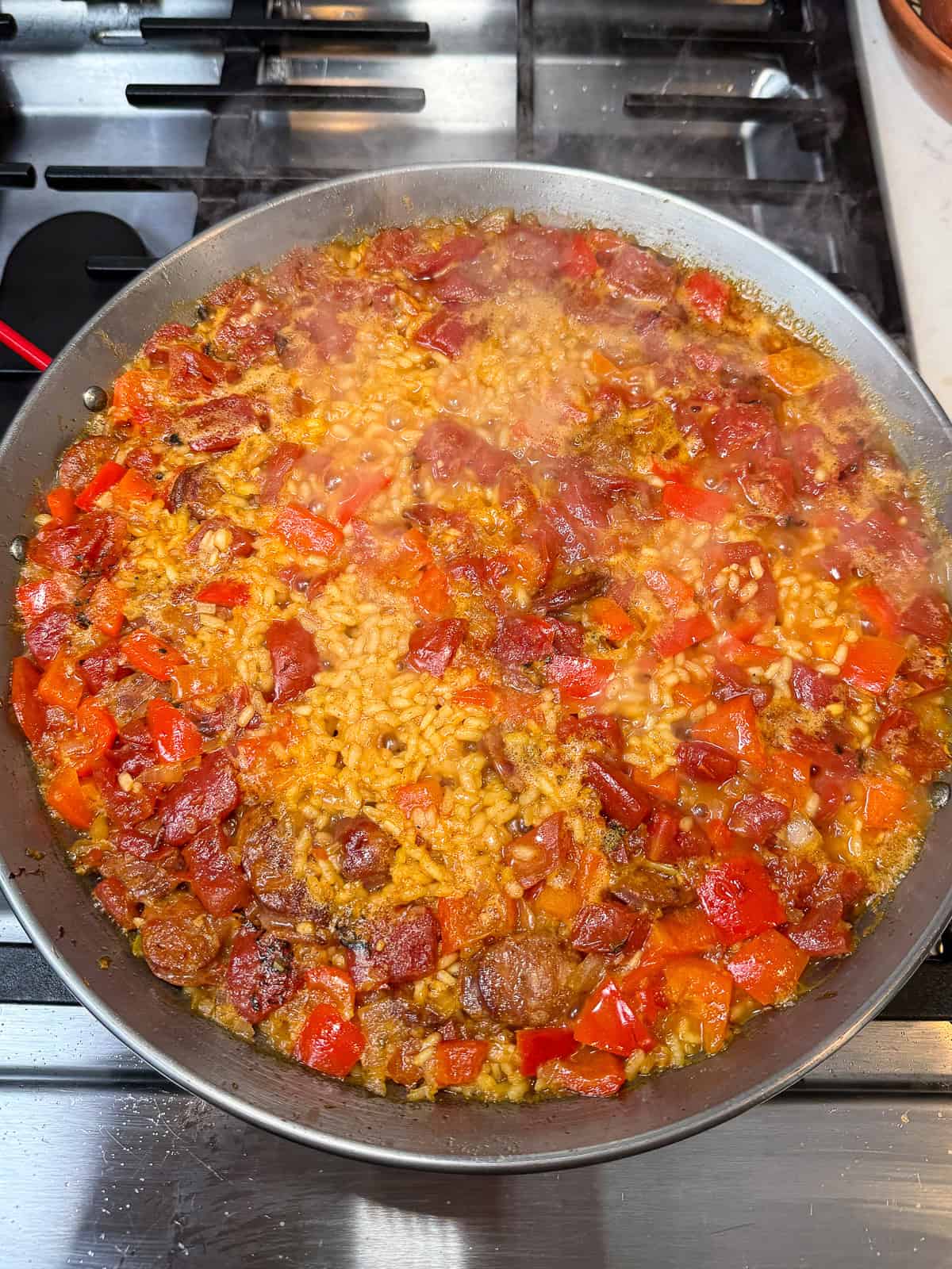 Cook the paella rice until most of the liquid has absorbed before adding the shellfish.