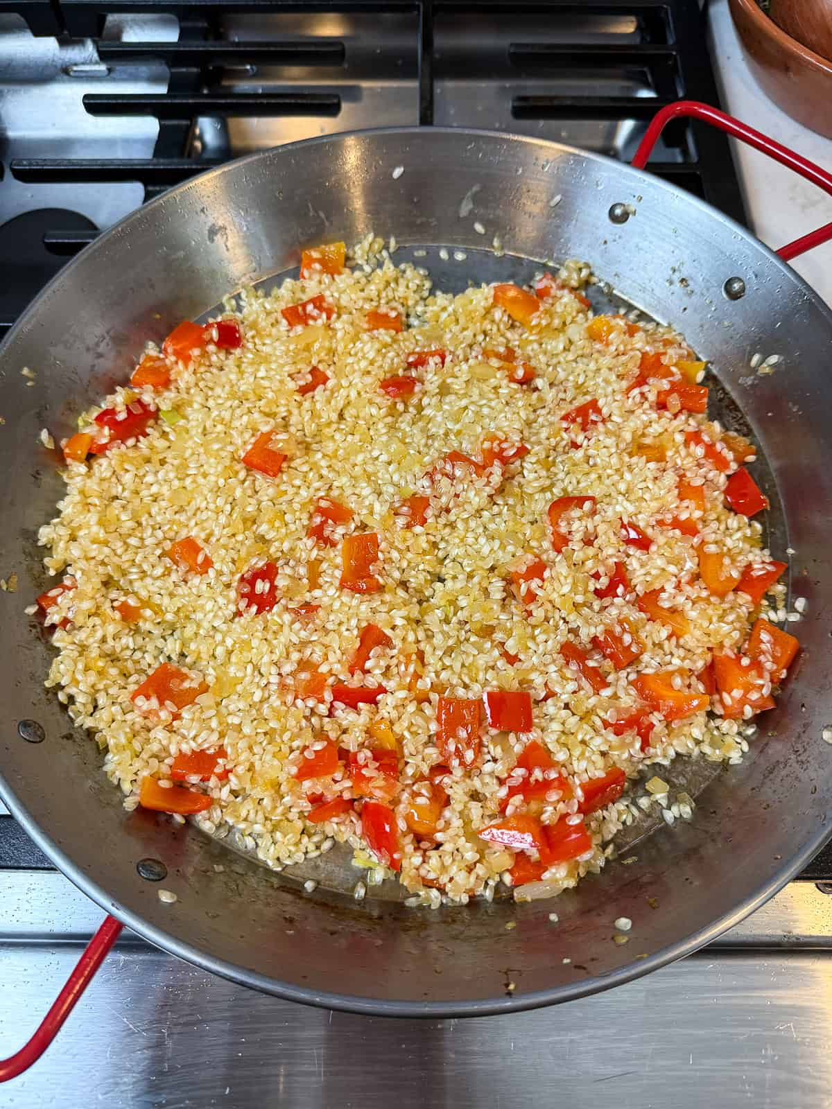 Saute the paella rice in the reserved chorizo fat with the aromatics.