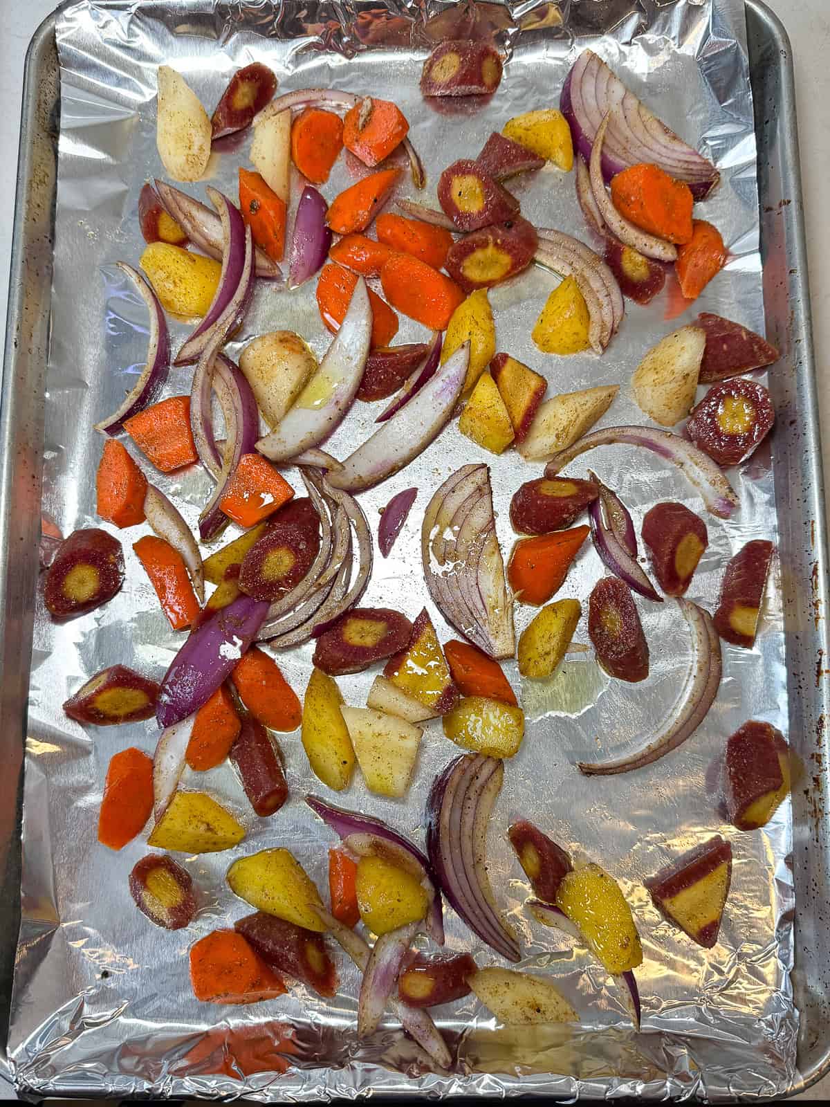 Place chopped carrots and onions on a foil lined baking sheet and toss with cumin, coriander, salt, pepper and olive oil.
