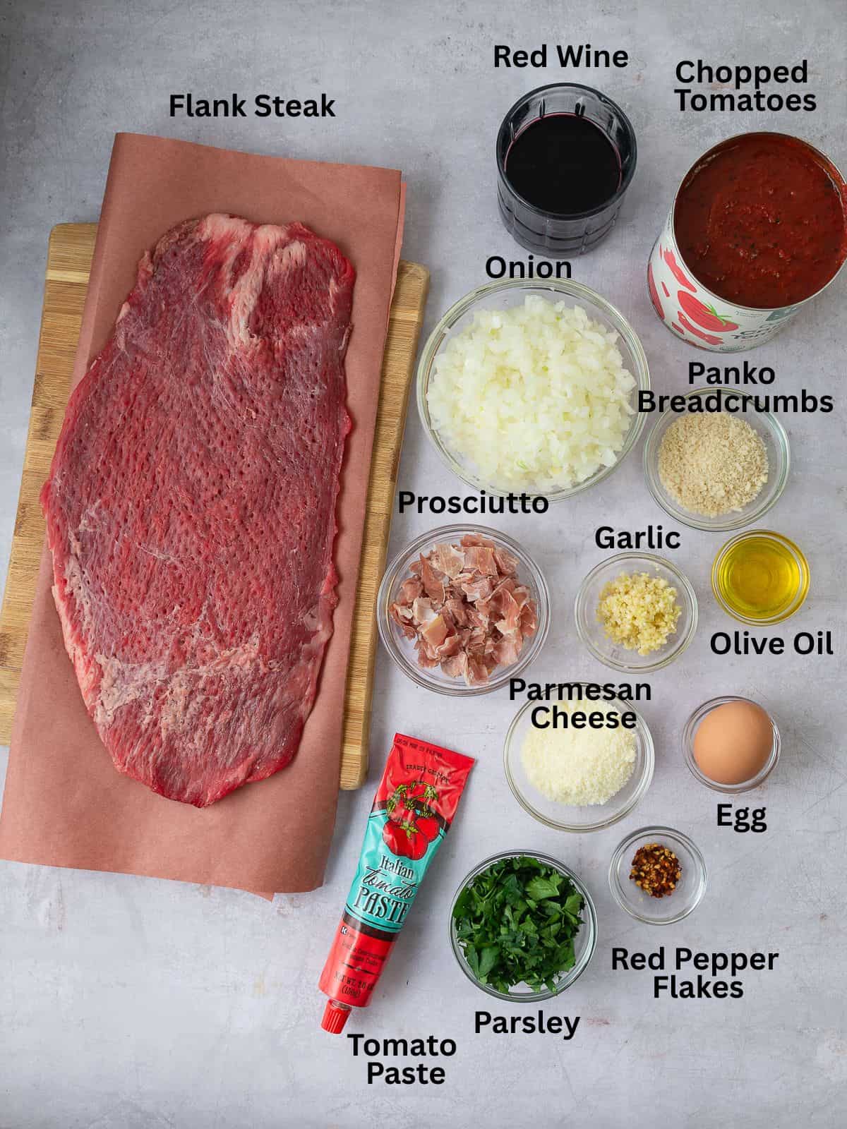 Ingredients for beef braciole with prosciutto, parmesan cheese, tomatoes, wine and aromatics.