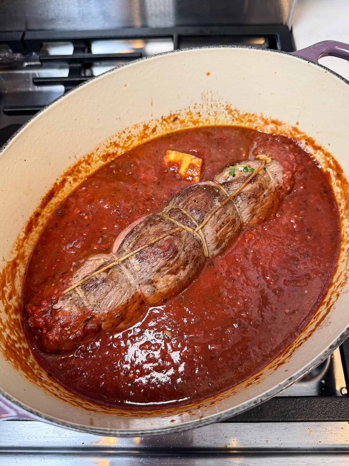 Braise the sweared braciole in the tomato sauce and add a chunk of parmesan cheese.