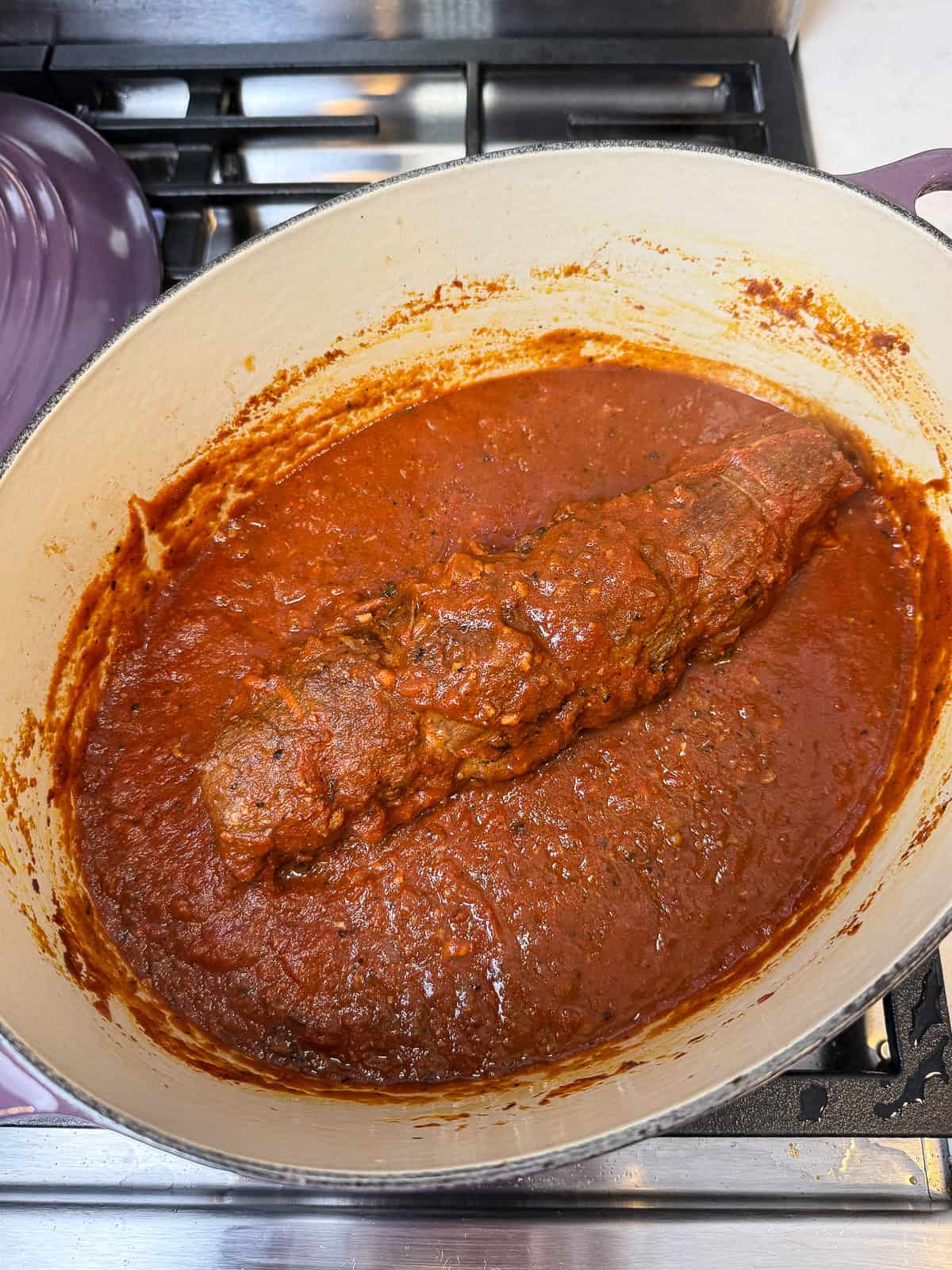 Cook the beef braciole in the tomato sauce until the braciole is cooked through and tender and the sauce has reduced and thickened.