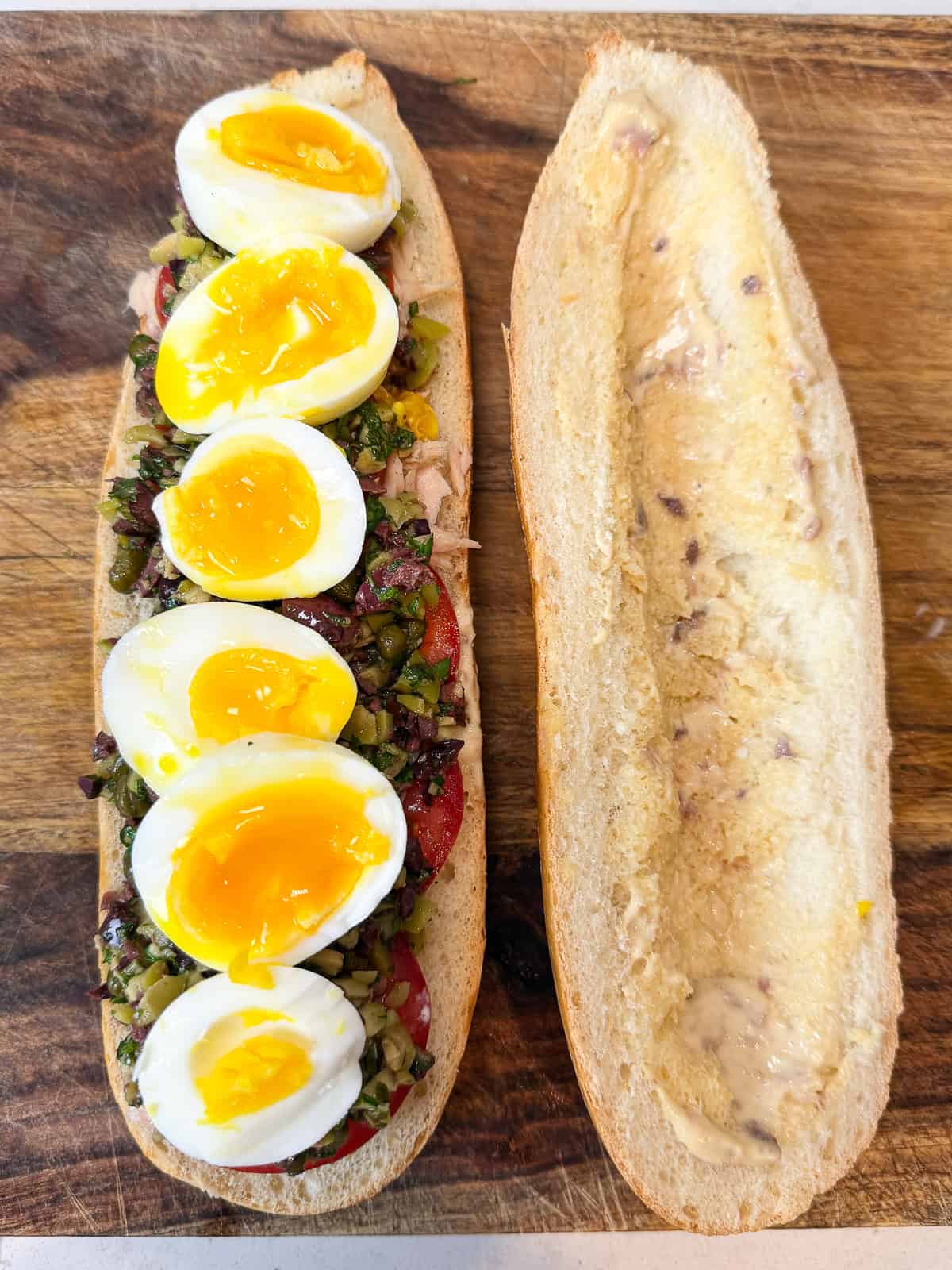 Slice the medium boiled egg and layer that onto the nicoise sandwich.