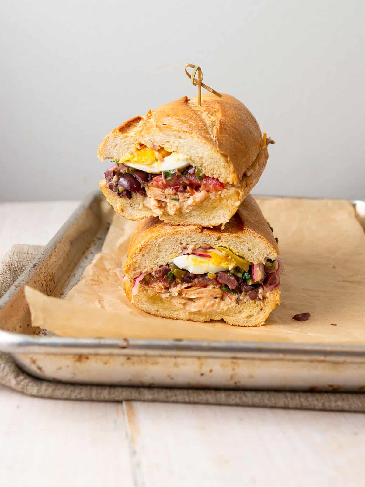 This nicoise sandwich is inspired by the nicoise salad and is layered with tuna, chopped olives, a perfect medium boiled egg and pickled onions.