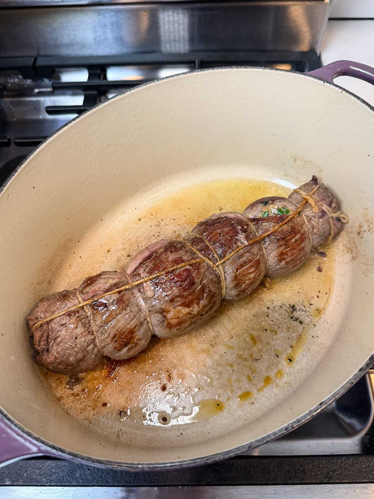 Sear the beef braciole on all sides, then set aside.