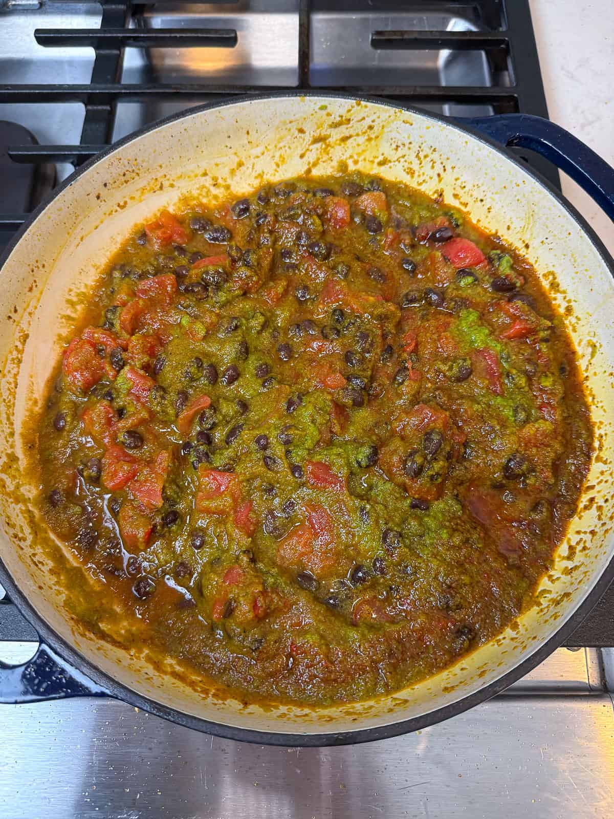 Add the sofrito to the chopped tomatoes and black beans.