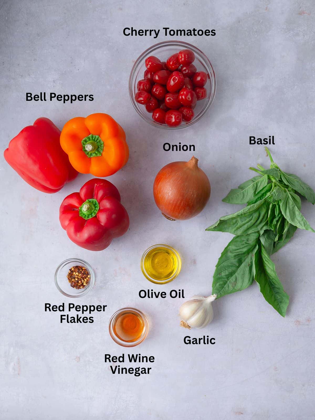Ingredients for Italian peperonata, including bell peppers, cherry tomatoes, onion and fresh basil.
