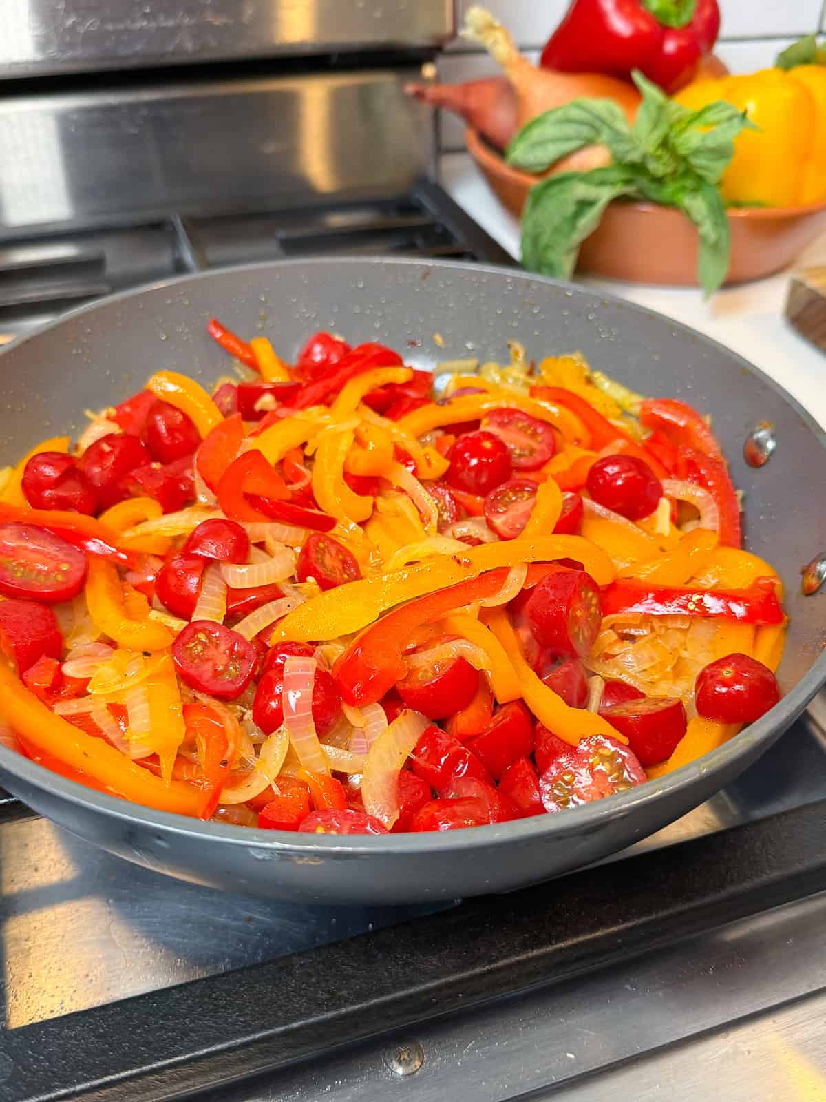 Add tomatoes to the sautéed onions and bell peppers..