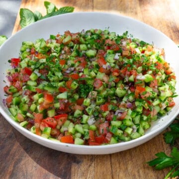 Middle Eastern chopped salad aka shirazi salad is layered with finely diced tomato, cucumber and onion with fresh herbs and lemon.