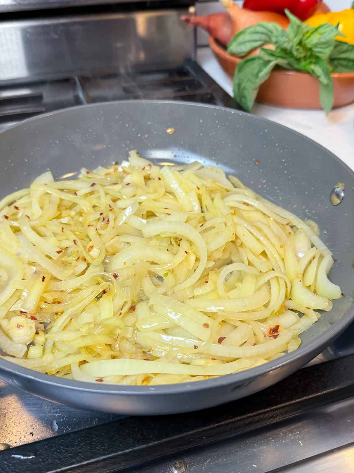 Add sliced onions to the sautéed garlic and give them a head start.