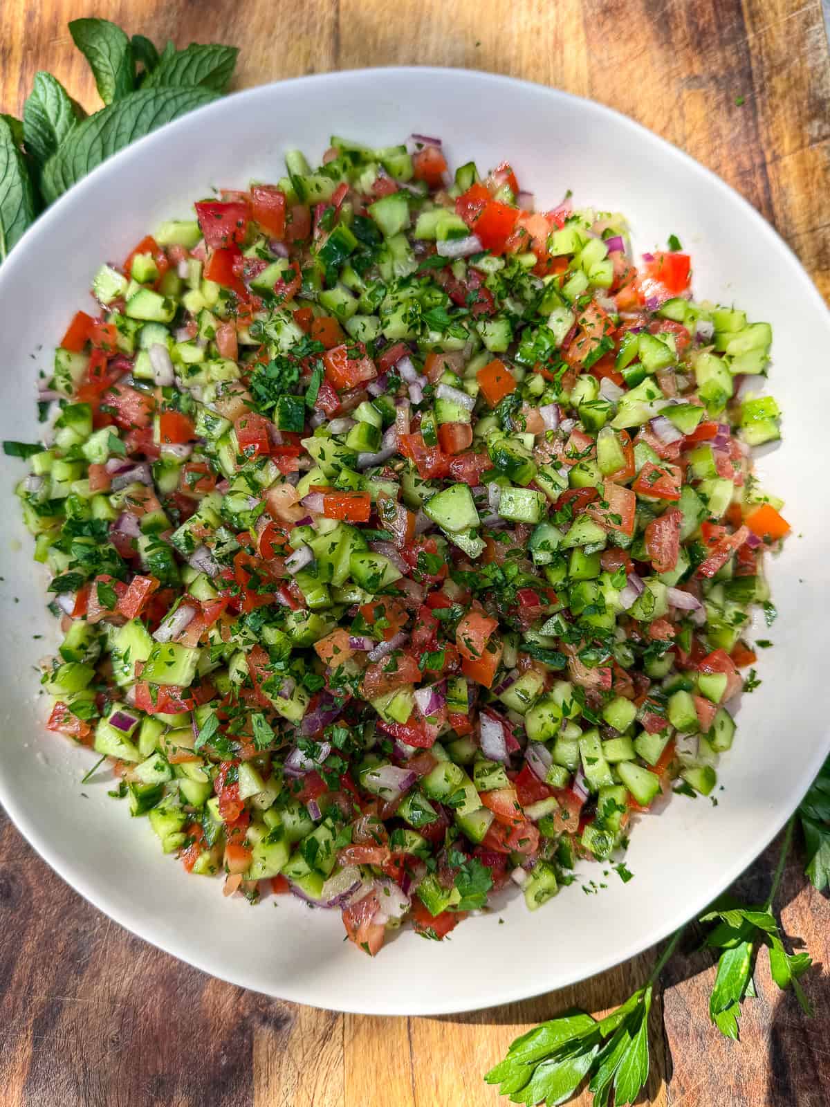 This chopped tomato and cucumber salad is commonly known as shirazi salad. It's simply dressed with fresh herbs, olive oil and lemon juice.