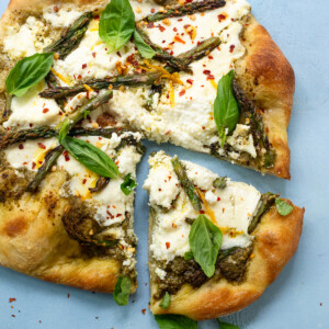 White pesto pizza with grilled asparagus, ricotta and bright pesto.