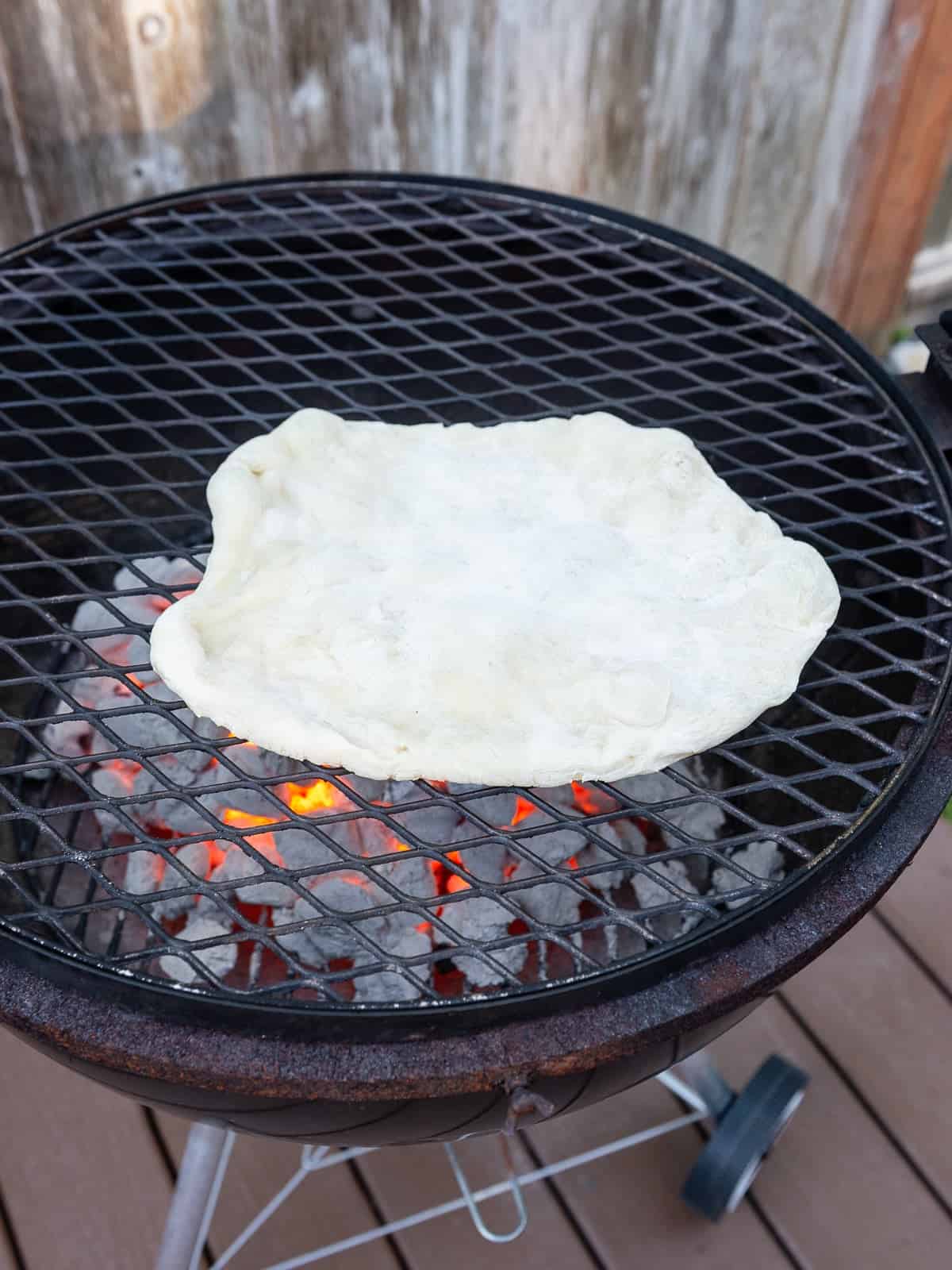 Place the stretched out pizza dough right onto the hot grill.