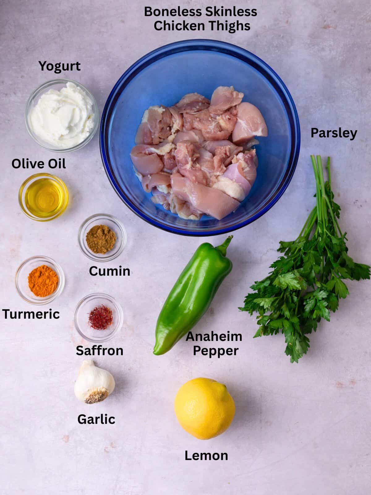 Ingredients for saffron yogurt chicken with spices, herbs, lemon and garlic.