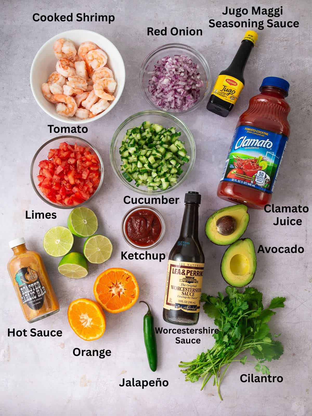 Ingredients for Mexican shrimp cocktail, including clamato juice, Jugo Maggi, diced vegetables and avocado,