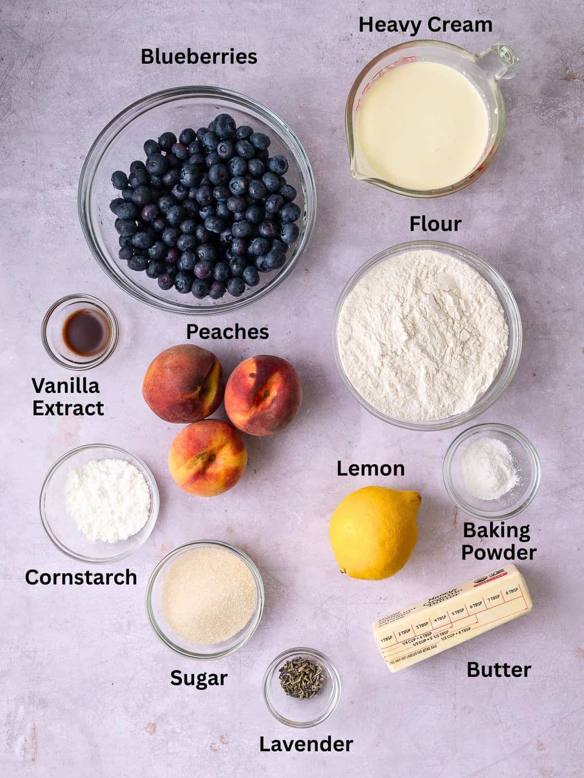 Ingredients for blueberry peach cobbler including heavy cream, dried lavender and lemon.