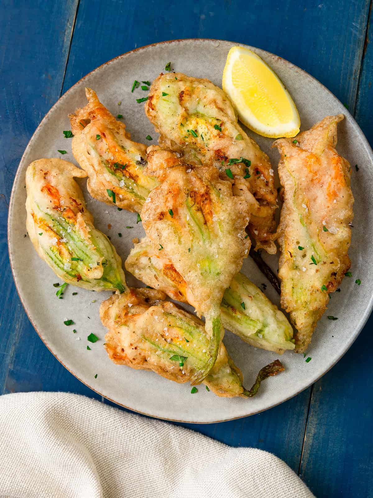Ricotta cheese stuffed squash blossoms are fried until perfectly crisp and golden.