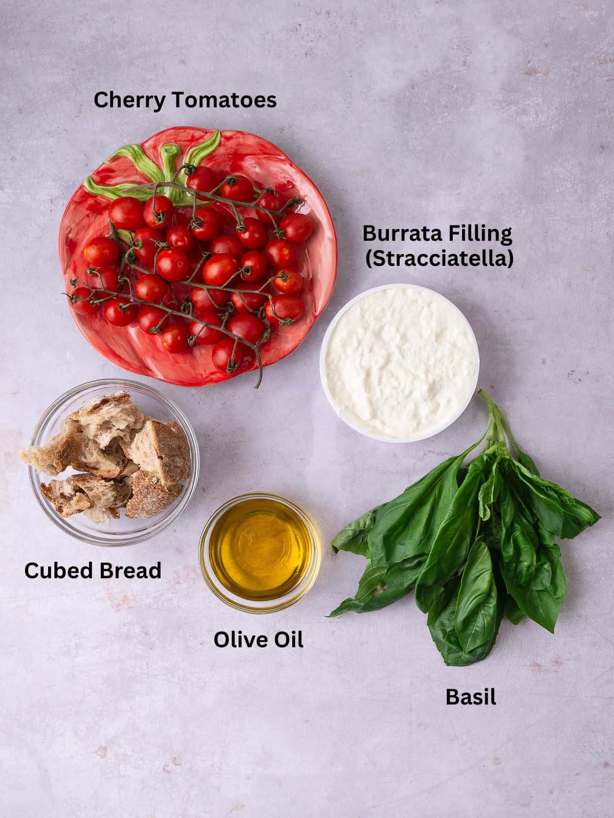 Ingredients for frozen cherry tomato granita, including burrata filling, basil, olive oil and breadcrumbs.
