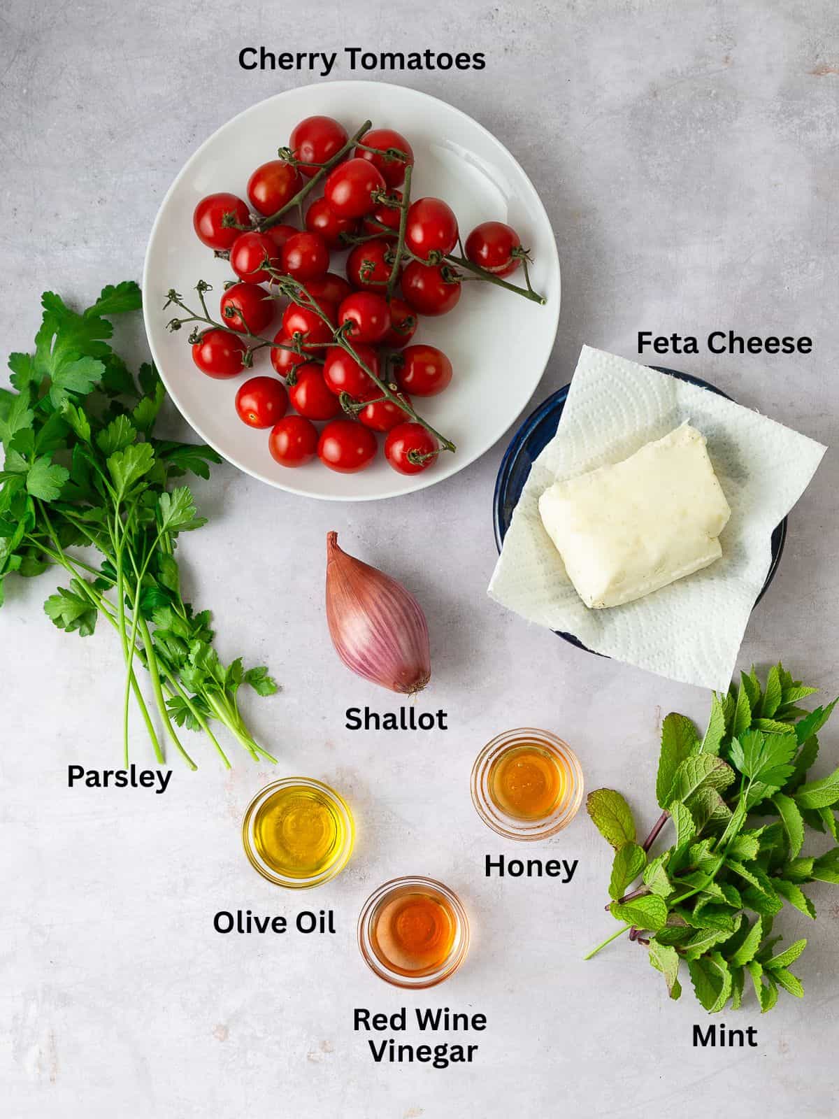 Ingredients for grilled cherry tomatoes with fresh herbs, olive oil and honey for the herb vinaigrette.