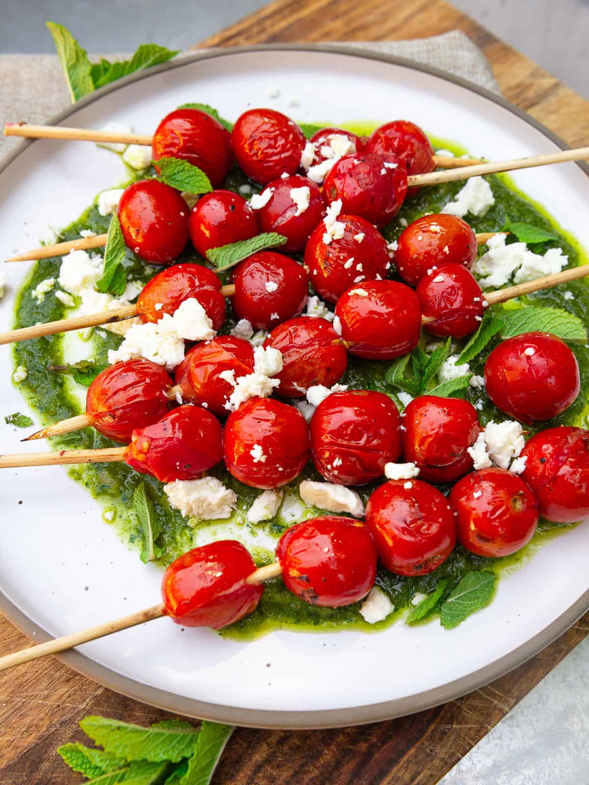 Grilled cherry tomatoes served over a bright herb vinaigrette and crumbled feta.