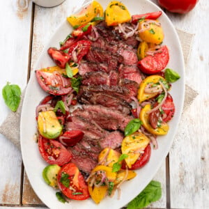 Grilled ribeye steak with a colorful heirloom tomato salad.