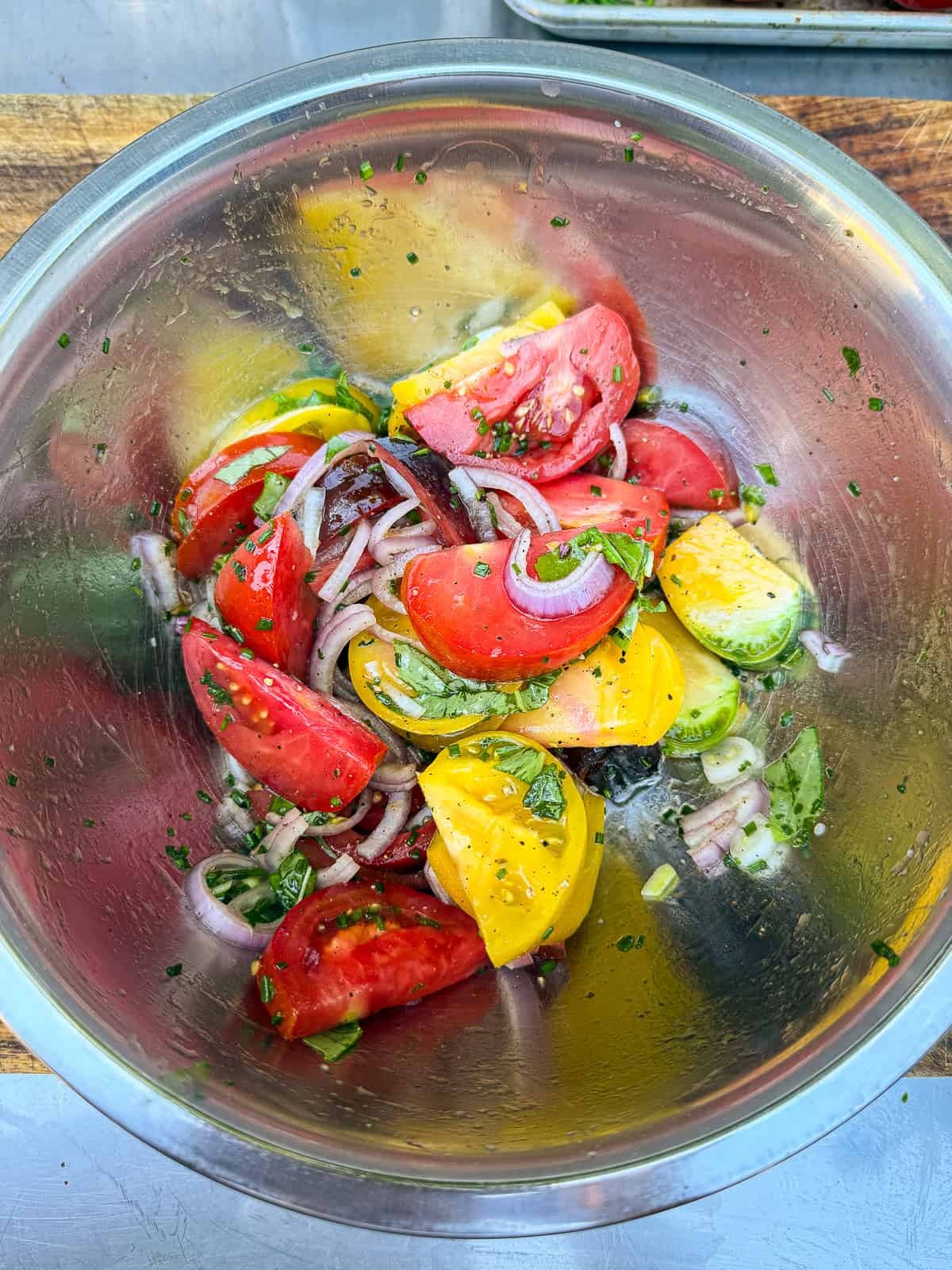 Toss the heirloom tomato wedges with sliced shallot, olive oil, vinegar, fresh herbs and season with salt and pepper.