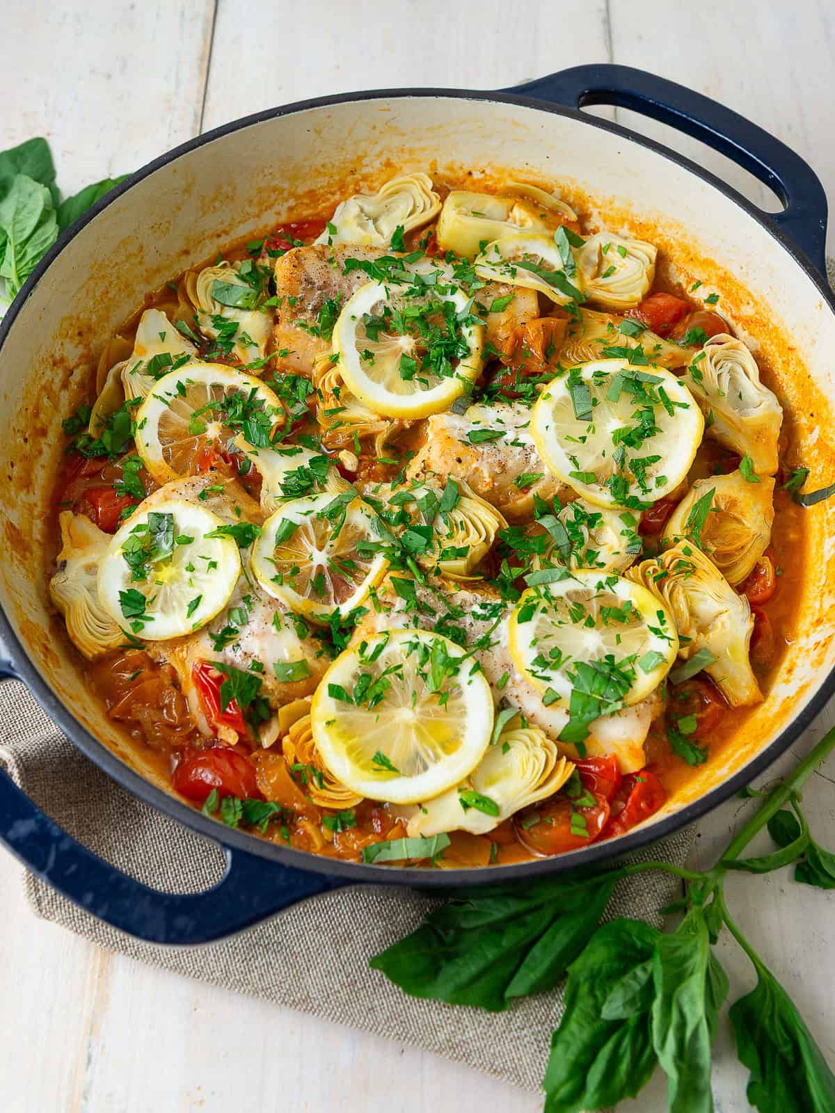 This one pan fish recipe is made with delicate cod simmered in cherry tomatoes with artichoke hearts and lemon.