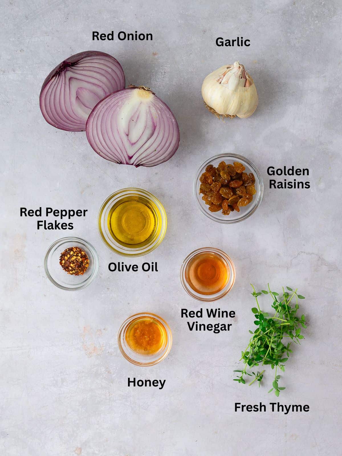 Ingredients for onion agrodolce, including golden raisins, garlic and vinegar.