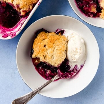 This peach and blueberry cobbler is baked until the fruit bursts and sweetens and is topped with a lavender biscuit topping.