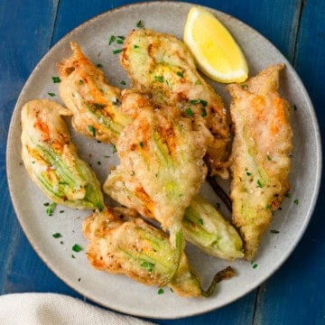 These golden fried squash blossoms are filled with a bright and creamy ricotta cheese mixture.