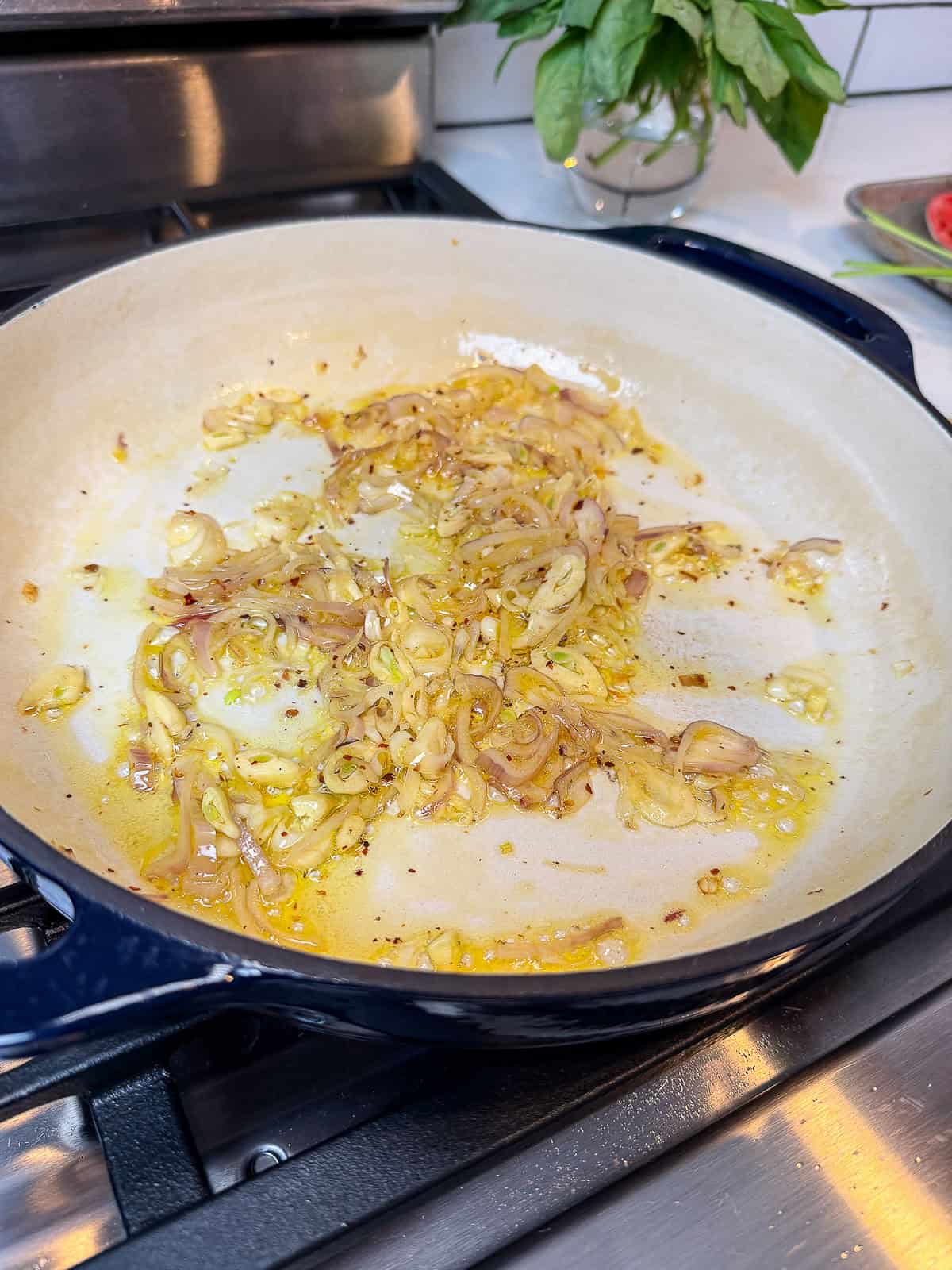 Saute sliced shallot and garlic in olive oil and butter until lightly golden.