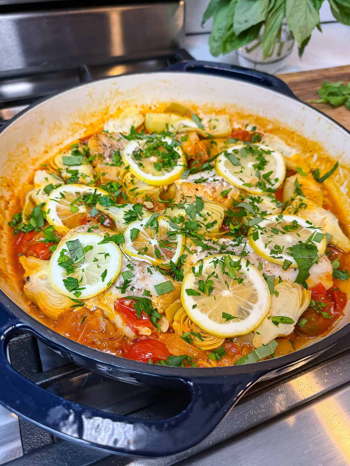 Simmer the cod in the tomatoes until just cooked through and garnish with fresh herbs on top.