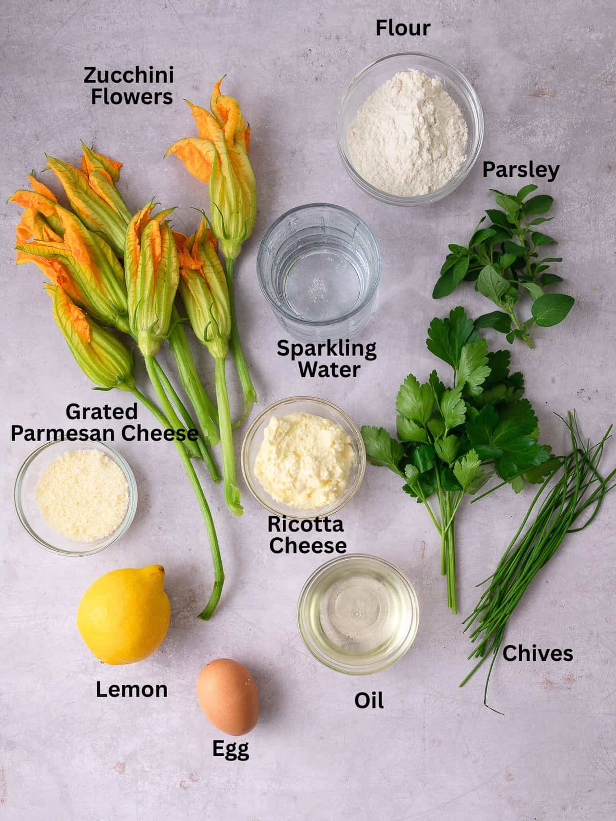 Ingredients for stuffed squash blossoms, including ricotta cheese parmesan cheese and fresh herbs.