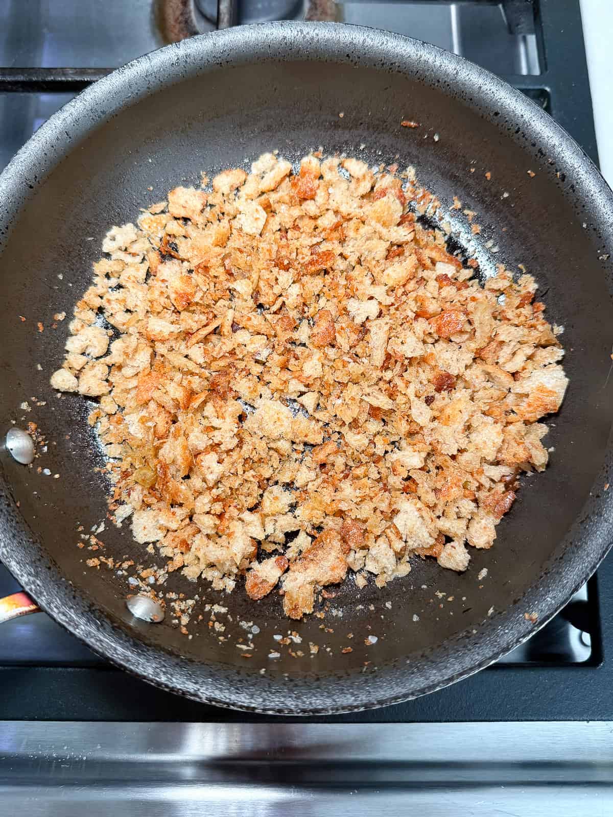 Drizzle olive oil in a skillet and toast the breadcrumbs over medium heat until lightly golden.