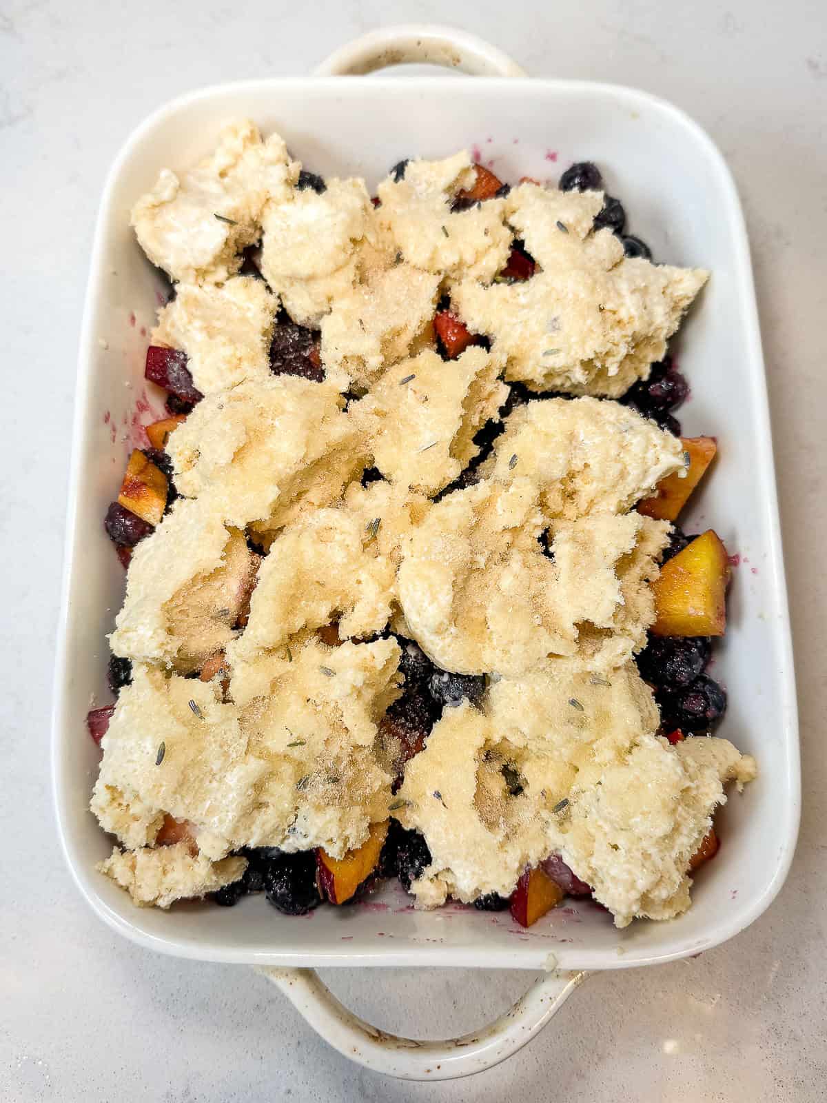 Layer the biscuit topping over the fruit in the casserole dish.