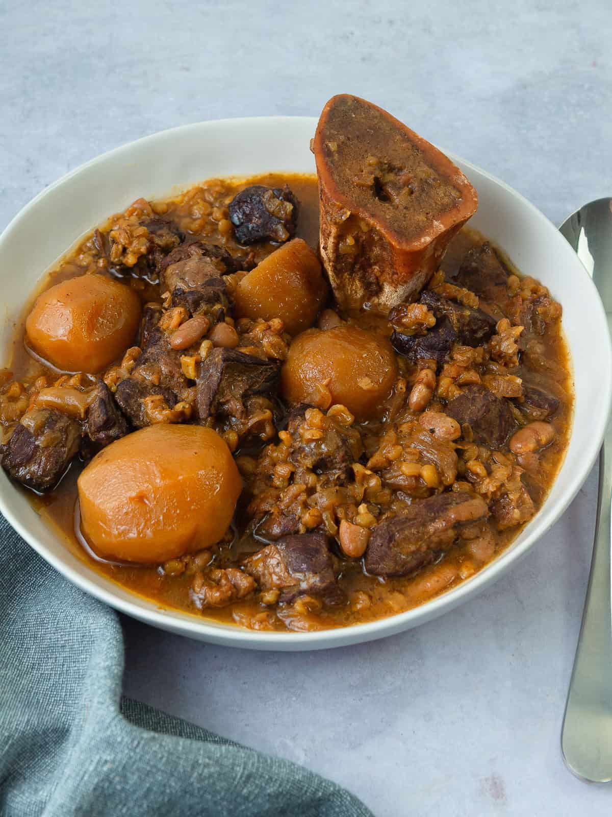 Traditional Jewish cholent with beef, beans, barley, and potatoes.
