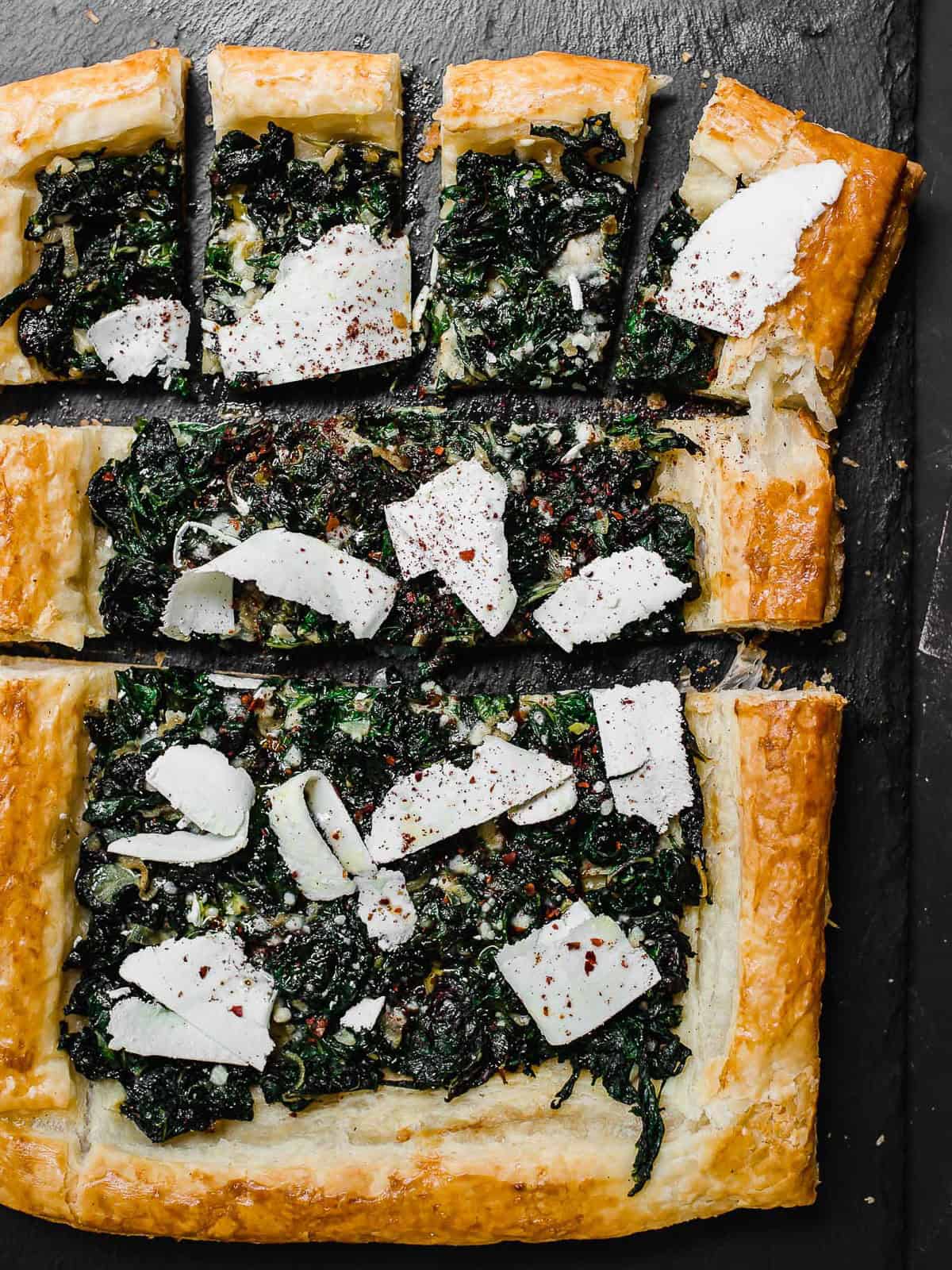 Savory chard tart with puff pastry and toped with shaved cheese.