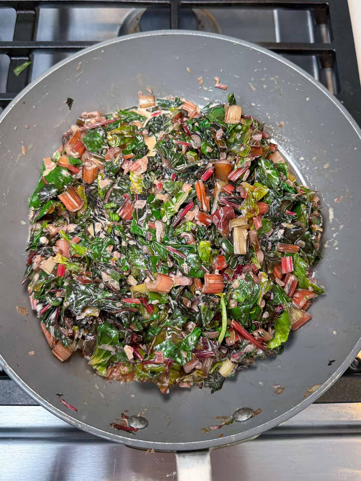 Stir the heavy cream and parmesan cheese into the sautéed chard stems and leaves.