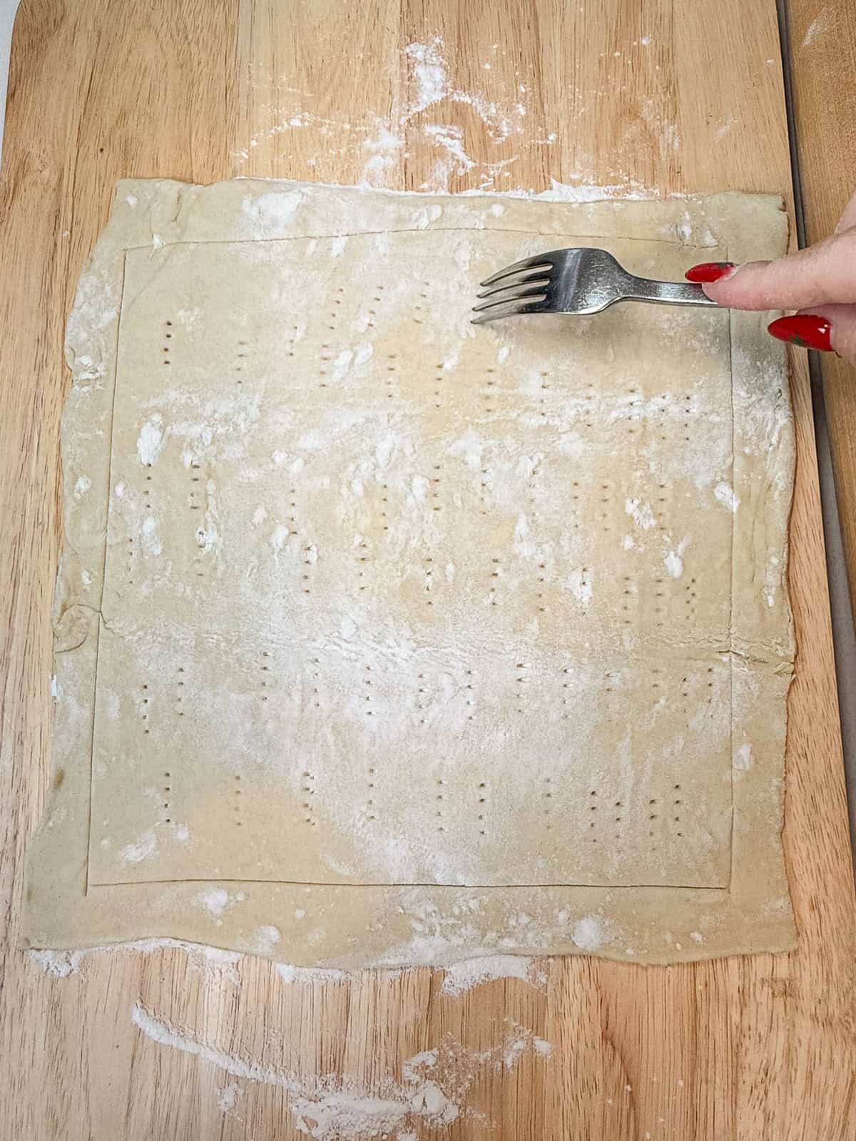 Use a fork and dock holes into the center of the rolled out puff pastry sheet.