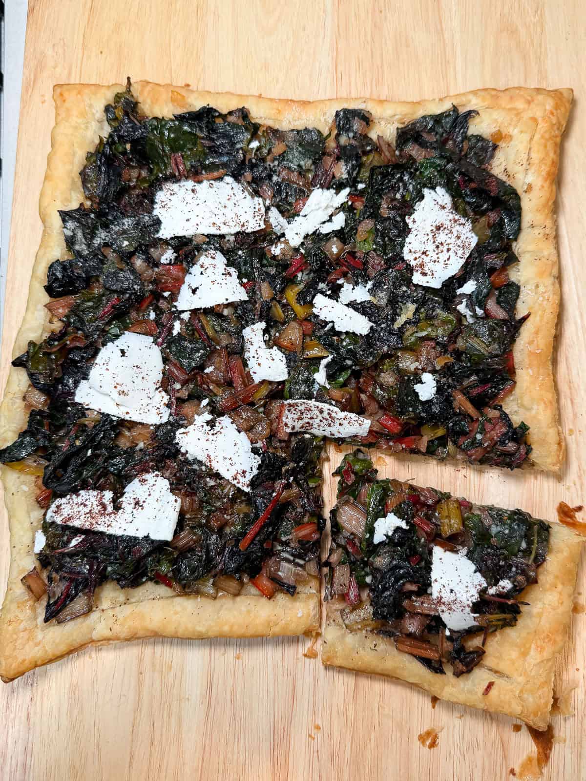 Garnish the chard tart with shaved ricotta salata (or parmesan cheese) and sprinkle of sumac.