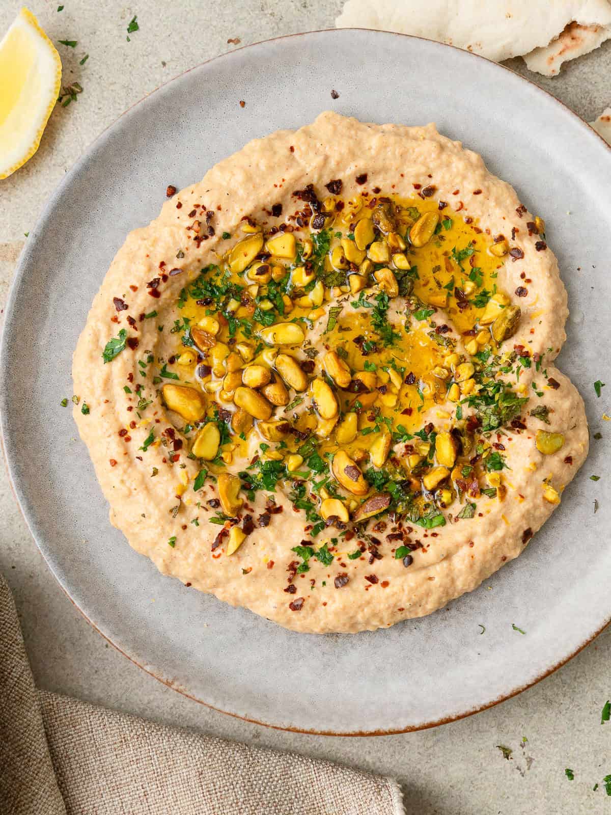 Smoky zucchini dip with tahini, lemon, fresh mint, pistachios, and olive oil.