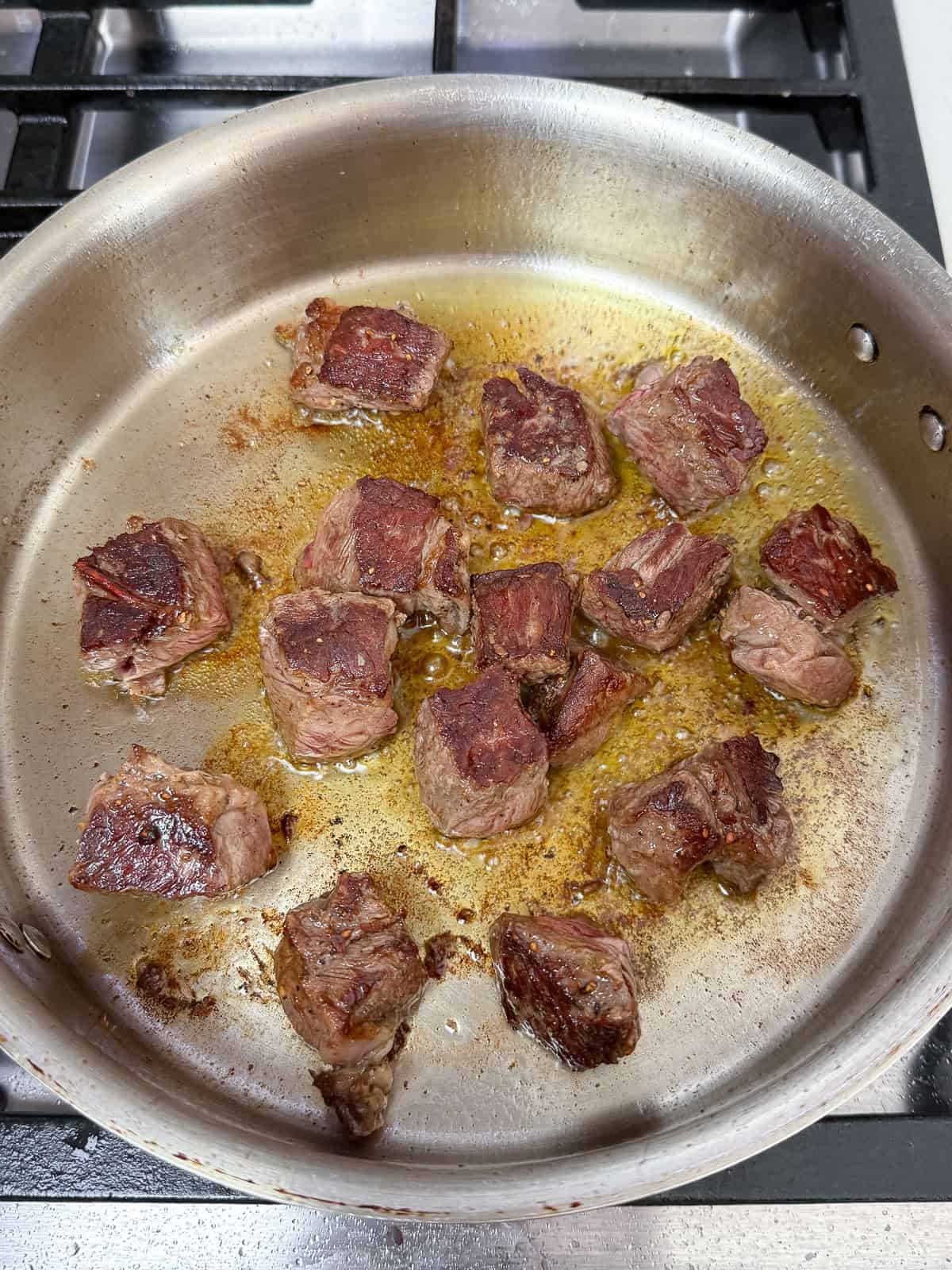 Sear the beef cubes until caramelized on all sides, then set aside.