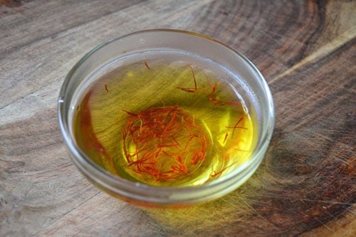 Steep saffron threads in a small bowl of water.
