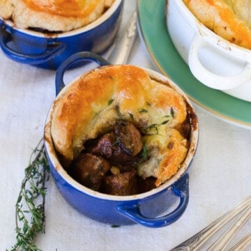 Beef Bourguignon pot pie with flaky puff pastry crust, tender beef, mushrooms, and pearl onions.