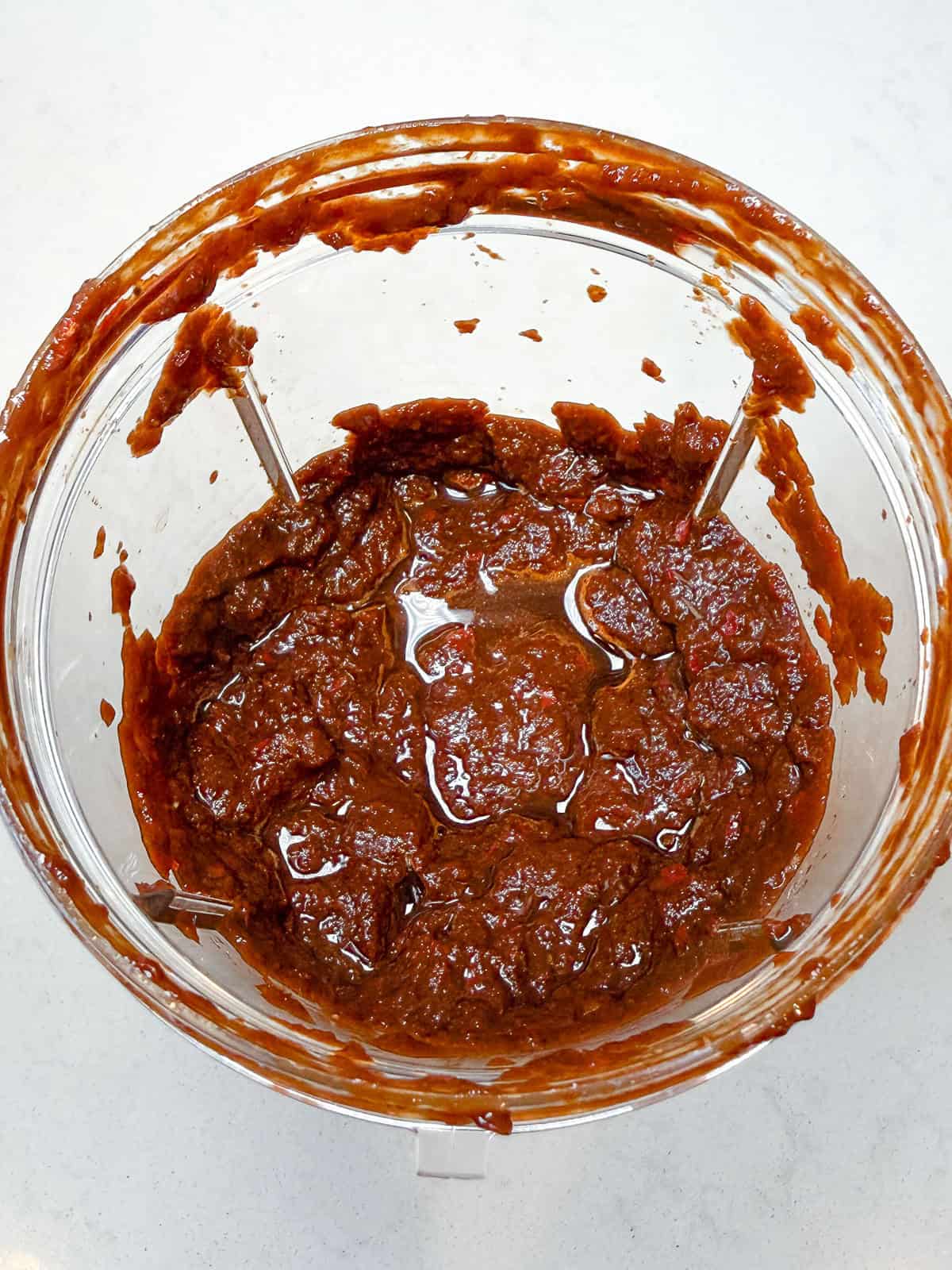 Add the softened dried chiles, onion, garlic and spices to a blender and blend until a paste forms.
