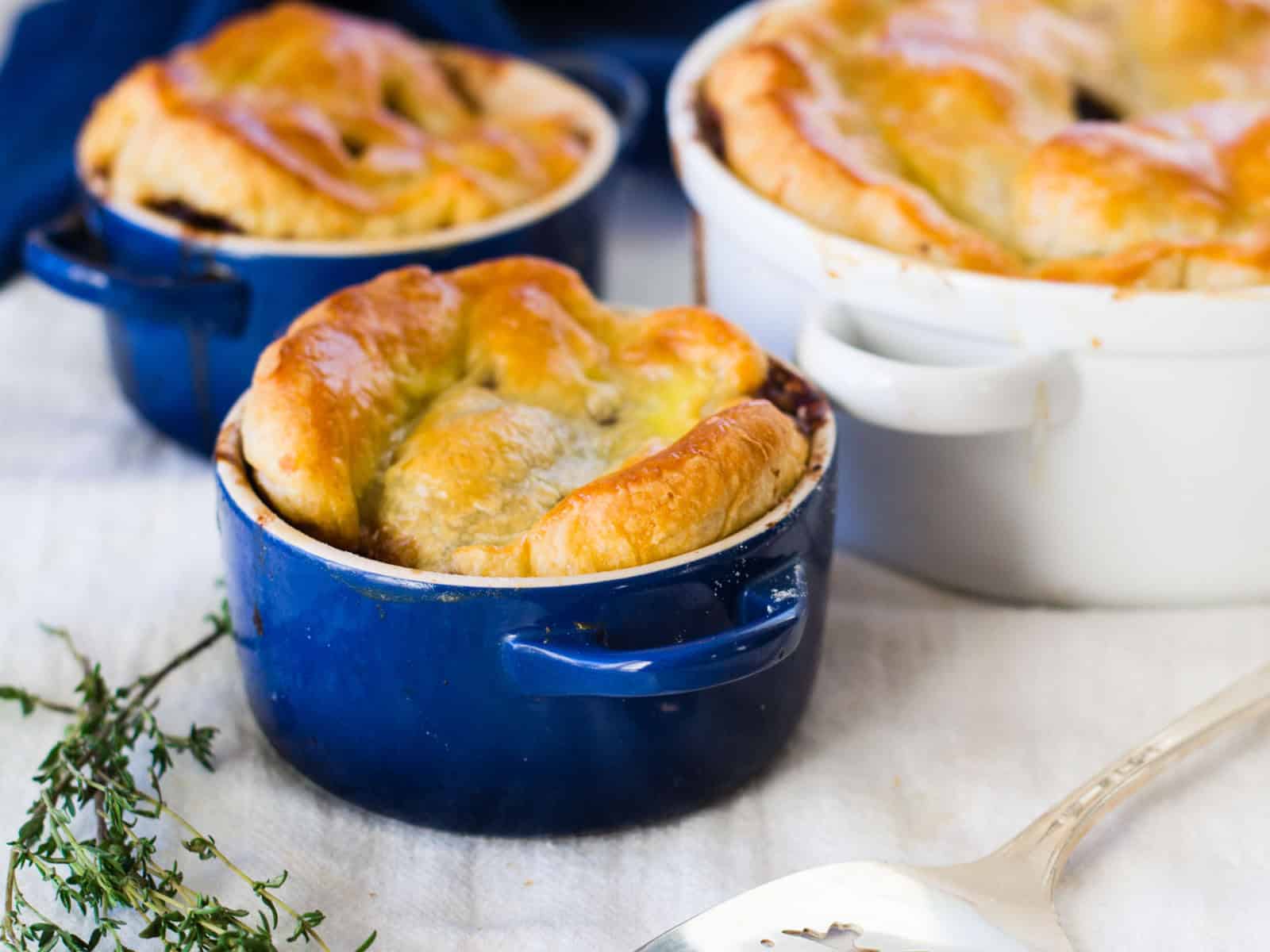 Homemade Beef Bourguignon pot pie with golden puff pastry crust.