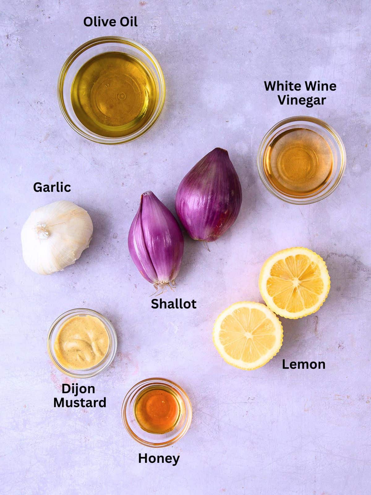 Ingredients for roasted shallot vinaigrette with garlic, lemon juice, honey and Dijon mustard.