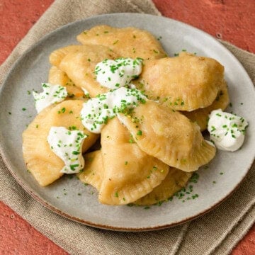 Homemade pierogies are filled with two different mixtures, with one filled with potato and cheese and the other with sauerkraut and sour cream.
