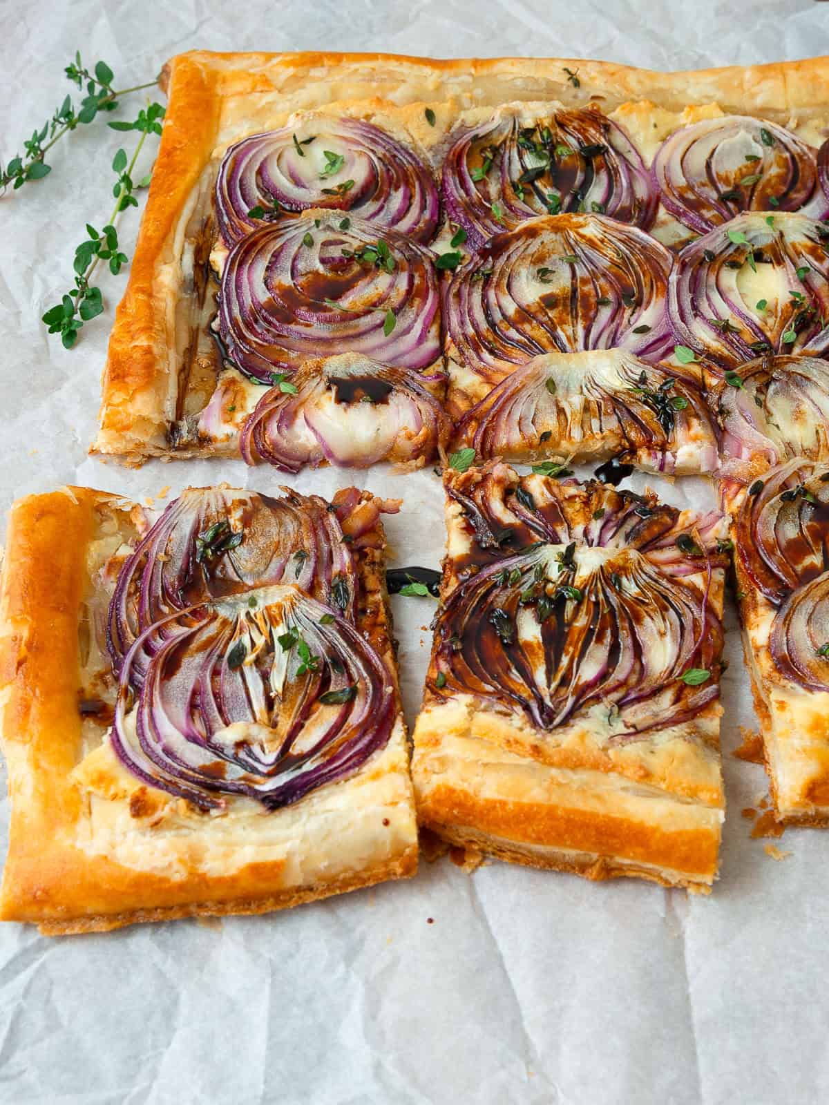 Puff pastry onion tart with creamy Boursin cheese, Parmesan, red onions, and aged balsamic.