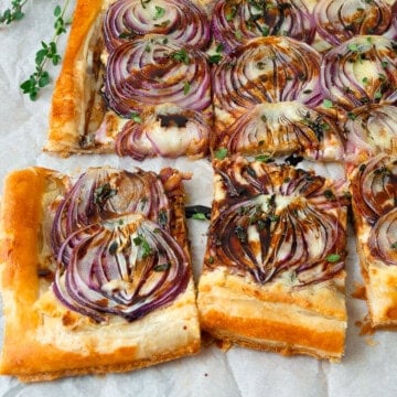 This onion boursin tart is made with puff pastry and layered with creamy boursin cheese, thinly sliced red onions, parmesan cheese and finished with a drizzle of balsamic.